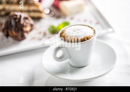 Tazza di caffè e dessert su piastra in cafe pasticceri o restautant. Foto Stock