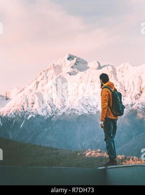 L'uomo avventuriero da solo godersi il tramonto vista montagne uno stile di vita attivo vacanze invernali outdoor avventura trekking viaggio solista Foto Stock