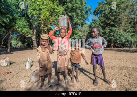 Bambini che portano l'acqua dal fiume, Berenty, Tolagnaro, provincia di Toliara, Madagascar Foto Stock