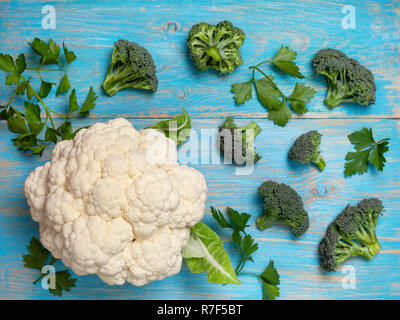 Cavolfiori e cavoli broccoli su un blu sullo sfondo di legno. vista da sopra Foto Stock