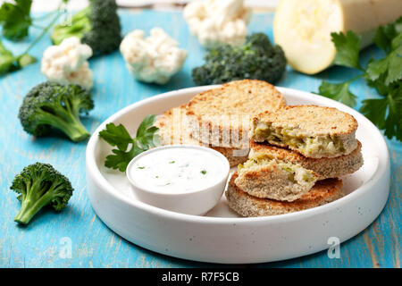 Cotolette di verdure e salsa in una ciotola bianco, cavolfiori, broccoli su uno sfondo di legno Foto Stock