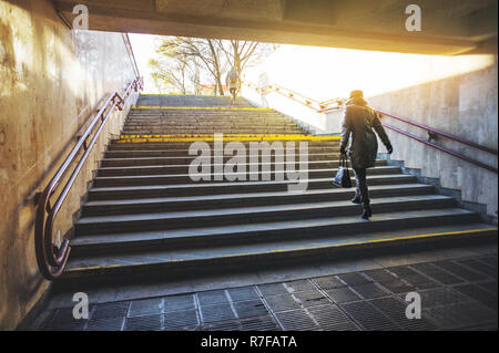 Persone salite le scale all'alba in un ambiente urbano. Turismo invernale in concetto di città Foto Stock