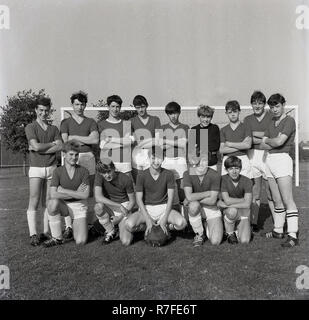 1965, giovani calciatori maschio al di fuori in piedi insieme per una foto del team....scollo a v magliette, stivali lucidato, spessa parastinchi e guardate che la palla! Foto Stock