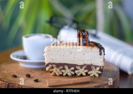 Churros cheesecake e caffè macchiato con libro e bicchieri sfondo sulla tavola di legno Foto Stock