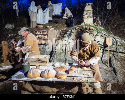 Vicenza, Italia - 30 dicembre 2017: Baker fare il pane durante una rievocazione storica nelle grotte di Villaga, Italia. Foto Stock