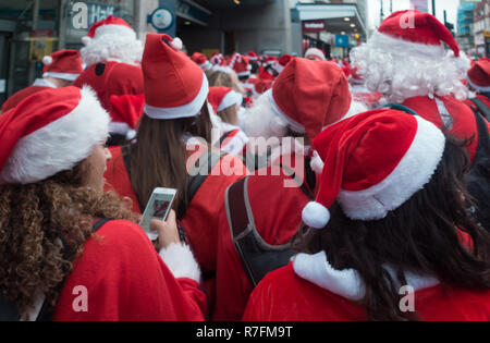 London, Regno Unito - Dicembre 2018 : gruppo di persone vestite di santa abiti e prendendo parte a un tema evento SantaCon Foto Stock