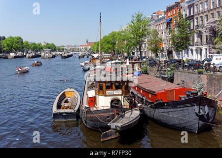 Barche sul fiume Amstel di Amsterdam, Paesi Bassi Foto Stock
