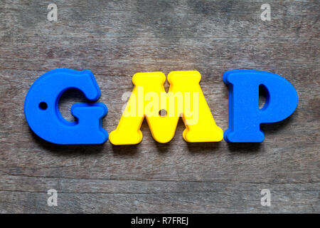 Alfabeto di colore in parola GMP (abbreviazione di buona prassi di fabbricazione) su uno sfondo di legno Foto Stock