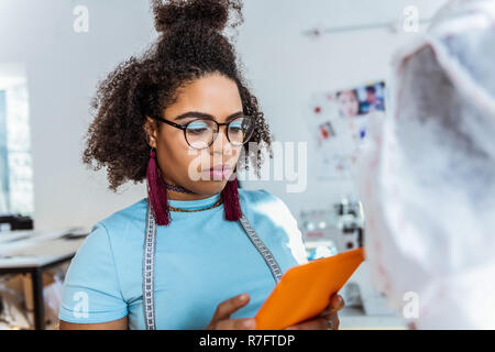 Americano africano a pelo corto lady indossando una luce brillante trucco blu Foto Stock