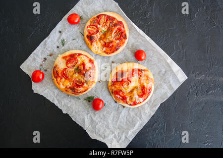 Mini pizze margheritas su una pergamena con una pietra nera ba Foto Stock