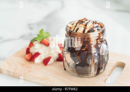 Brownie al cioccolato con gelato alla crema,montare la panna e fragola Foto Stock