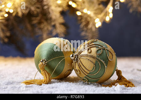Giocattoli di Natale sulla tavola nevoso su albero sullo sfondo delle luci Foto Stock