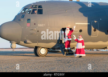 Babbo Natale e la sig.ra Claus onde come essi arrivano a bordo dell' Alaska Air National Guard HC-130J contro il re II aeromobili a visitare comunità remote durante il funzionamento di Santa Claus Novembre 1, 2018 in Emmonak, Alaska. Santa e la sig.ra Claus fornire regali di Natale, libri, zaini riempiti con forniture scolastiche, frutta e dolcetti per i giovani in remote comunità rurali in Alaska. Foto Stock