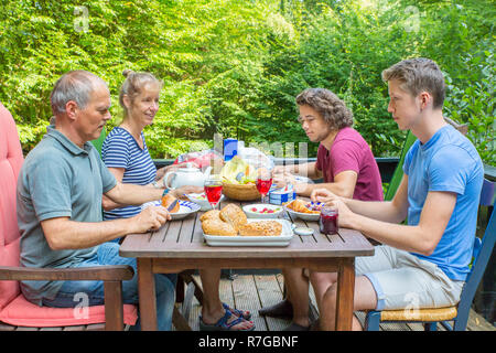 La famiglia europea di mangiare il pranzo sulla terrazza in natura Foto Stock