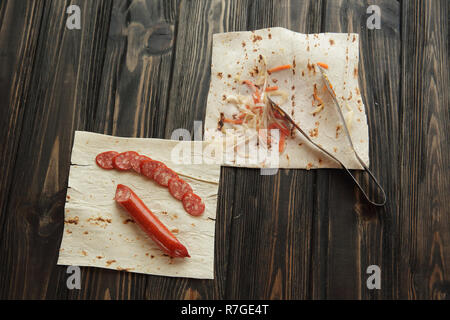 Salsiccia casalinga con pane pita su sfondo di legno Foto Stock