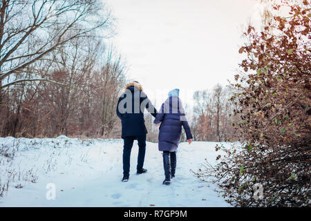 Bella amare giovane passeggiate nel bosco invernale insieme. Le persone felici avendo divertimento all'aperto Foto Stock