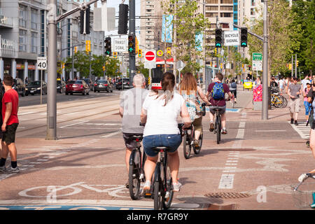 I ciclisti utilizzando una pista ciclabile su Martin Goodman Trail che segue la Toronto waterfront su Queens Quay. Città di Toronto, Ontario, Canada. Foto Stock