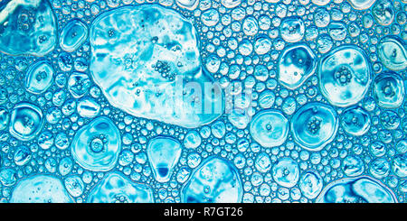 Colore sfondo astratto in toni azzurri, gocce di olio di diverse dimensioni poste su una superficie di acqua Foto Stock