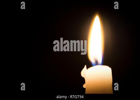 Masterizzazione singola candela fusa con forcella offuscata della fiamma contro uno sfondo scuro Foto Stock