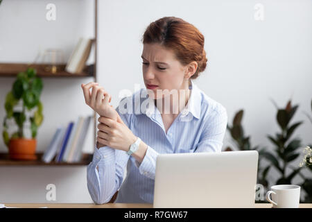 Business donna avente il dolore al polso durante il lavoro Foto Stock