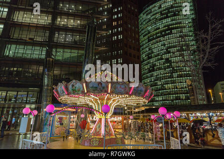 Berlino, Germania - 13 novembre 2018: la gente visita notte mercatino di Natale con la giostra su Potsdamer Platz. Si tratta di un importante piazza pubblica e traffi Foto Stock