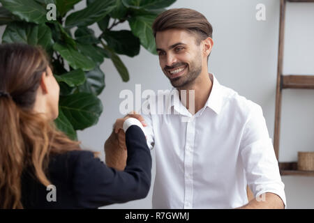 Saluto amichevole tra imprenditore e imprenditrice in offic Foto Stock