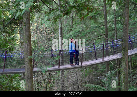 Coppia essendo affettuoso a Treetops avventura Canyon e luci, del Ponte Sospeso di Capilano Park, North Vancouver, British Columbia, Canada Foto Stock