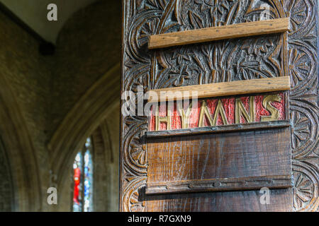 Ornati in legno intagliato scheda inno nella chiesa di San Pietro e di San Paolo, Olney, Buckinghamshire, UK Foto Stock