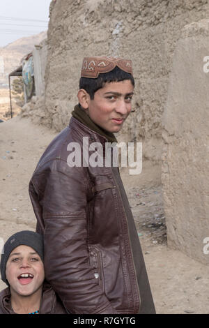 Ragazzo la cui famiglia è stata spostata dalla provincia di Helmand a causa dei talebani. Egli vive in condizioni difficili in un campo di rifugiati vicino a Kabul, Afghanistan. Foto Stock