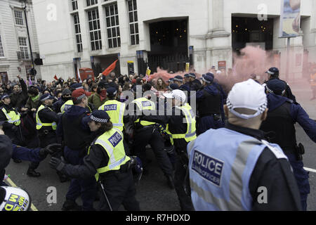 London, Greater London, Regno Unito. Il 9 dicembre, 2018. Gli ufficiali di polizia contengono manifestanti marciano a Whitehall durante la manifestazione contro il 'Brexit tradimento marzo ".Migliaia di persone sono scese nelle strade del centro di Londra a marzo contro il 'Brexit tradimento Marzo" organizzato da Tommy Robinson e UKIP. Contro manifestanti hanno fatto il loro modo da Portland Place a Whitehall, dove ha affrontato la folla. Durante la dimostrazione del contatore, vi è stata una forte presenza della polizia. Un gruppo di manifestanti del contatore, che divenne separate dalla principale di protesta, erano corralled dalla polizia per av Foto Stock