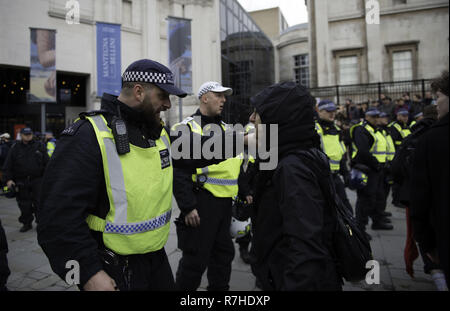 London, Greater London, Regno Unito. Il 9 dicembre, 2018. Funzionario di polizia sostenendo con un manifestante durante la manifestazione contro il 'Brexit tradimento marzo ".Migliaia di persone sono scese nelle strade del centro di Londra a marzo contro il 'Brexit tradimento Marzo" organizzato da Tommy Robinson e UKIP. Contro manifestanti hanno fatto il loro modo da Portland Place a Whitehall, dove ha affrontato la folla. Durante la dimostrazione del contatore, vi è stata una forte presenza della polizia. Un gruppo di manifestanti del contatore, che divenne separate dalla principale di protesta, erano corralled dalla polizia per evitare un incontro Foto Stock