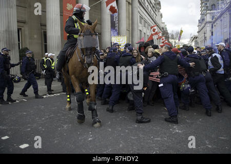 London, Greater London, Regno Unito. Il 9 dicembre, 2018. Gli ufficiali di polizia contengono manifestanti marciano a Whitehall durante la manifestazione contro il 'Brexit tradimento marzo ".Migliaia di persone sono scese nelle strade del centro di Londra a marzo contro il 'Brexit tradimento Marzo" organizzato da Tommy Robinson e UKIP. Contro manifestanti hanno fatto il loro modo da Portland Place a Whitehall, dove ha affrontato la folla. Durante la dimostrazione del contatore, vi è stata una forte presenza della polizia. Un gruppo di manifestanti del contatore, che divenne separate dalla principale di protesta, erano corralled dalla polizia per av Foto Stock