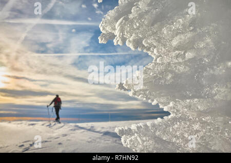 Naturale di formazioni di ghiaccio al tramonto, cross-country sciatore silhouette in distanza di messa a fuoco selettiva. Foto Stock