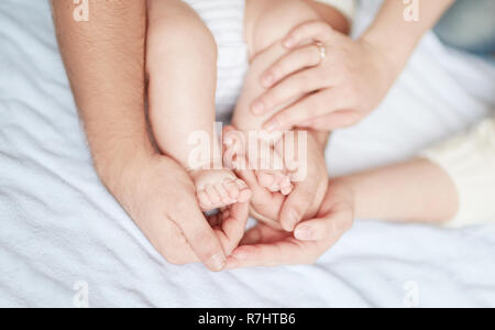 Bambini I piedi nelle mani dei genitori Foto Stock