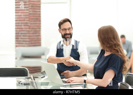 Imprenditore e imprenditrice stringono le mani sopra la scrivania Foto Stock