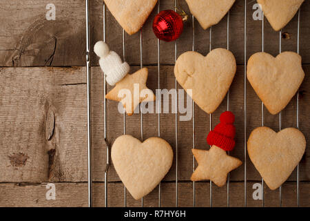 Le decorazioni di Natale con Gingerbread cookie, festosa giocattolo decorativa sul vassoio e il vintage sfondo di legno. Rustico Hygge xmas sfondo di cottura Foto Stock