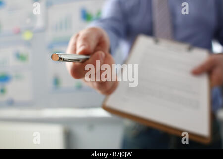 Braccio maschio in tuta offerta sotto forma di contratto negli appunti Foto Stock