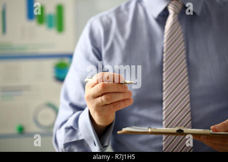 Braccio maschio in tuta offerta sotto forma di contratto negli appunti Foto Stock