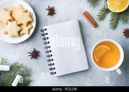 Tazza di tè e biscotti, rami di pino, bastoncini di cannella, anice stelle. Natale, concetto d'inverno. Lay piatto vista dall'alto. Foto Stock