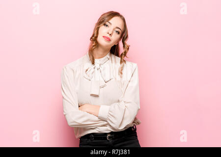 Grave infelice femmina ha aspetto accattivante, essendo triste dopo litigare con la persona vicina, acciglia faccia in insoddisfazione, isolato su rosa di sfondo per studio. Umano emozioni negative concept Foto Stock