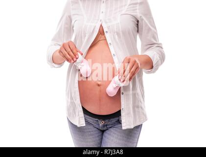 Donna incinta holding baby calzini sul suo stomaco. Foto Stock