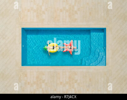 Vista aerea della donna e un uomo sul materasso gonfiabile in piscina. Foto Stock
