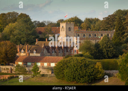 San Bartolomeo è la Chiesa, Ewelme, con la scuola del villaggio e gli ospizi di carità nella luce della sera Foto Stock