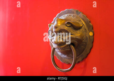 Porta in ottone respingente sul rosso porta del tempio Foto Stock