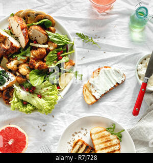 Ciotola di insalata fresca con bistecca di pollo e cavolfiore fritto su sfondo bianco con succo di pompelmo fresco vista superiore. Cibo sano concetto Foto Stock