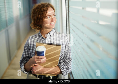 Allegro attraente dama di bere il caffè in corridoio Foto Stock