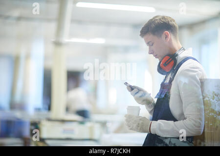 Grave giovane operaio edile utilizzando gadget a rottura Foto Stock