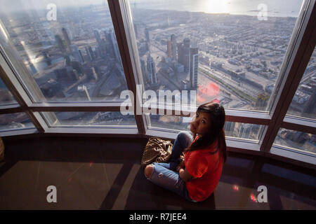 Una femmina di turisti asiatici si ammira il panorama di Dubai dalla panoramica piattaforma di osservazione del Burj Khalifa a Dubai, EAU. Foto Stock