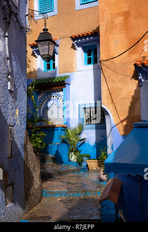 Il Marocco, Chefchaouen, Medina, fontana di acqua tra i tradizionali blu e giallo ocra case dipinte in corsia stretta Foto Stock