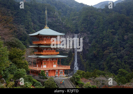 Madre e figlio in giacche gialle a piedi Seiganto tNachisan-ji pagoda a Kumano Nachi Santuario con la Nachi cade in background, Wakayama, Giappone, Asia Foto Stock